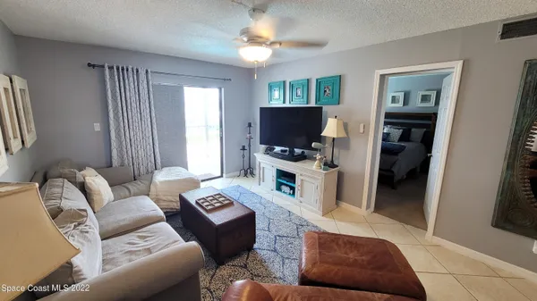 a living room with furniture a large window and a flat screen tv