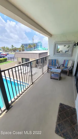 a view of a balcony with chairs and potted plants