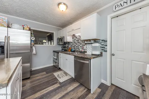 a kitchen with stainless steel appliances a refrigerator sink and stove