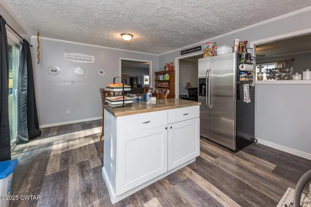 a bedroom with a large bed and a chandelier fan