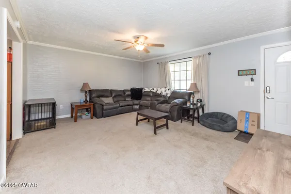 a living room with furniture and a ceiling fan