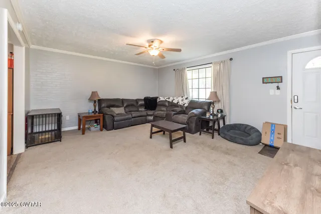 a living room with furniture and a ceiling fan
