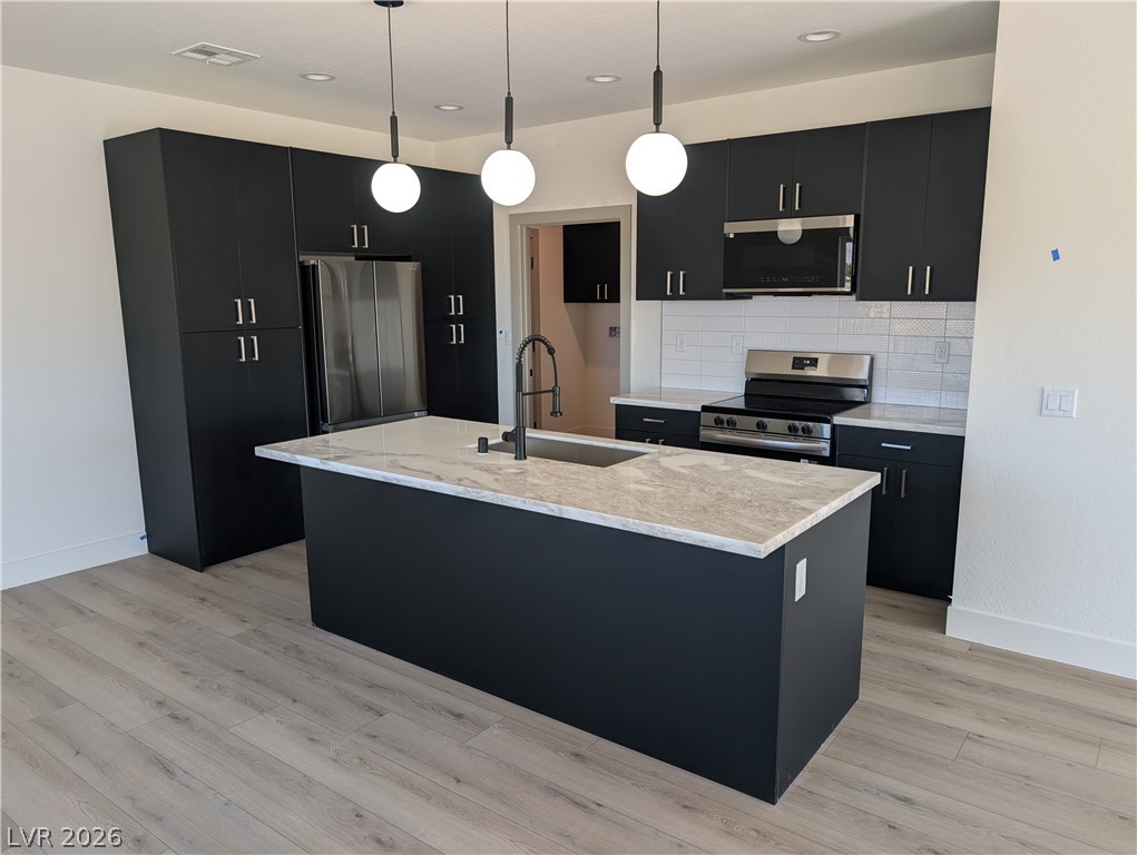 4670 Medicine Man Road Pahrump, NV 89048 - Photo 7 of 36 A contemporary kitchen features an island, ample cabinetry, and sleek appliances, perfect for culinary endeavors.