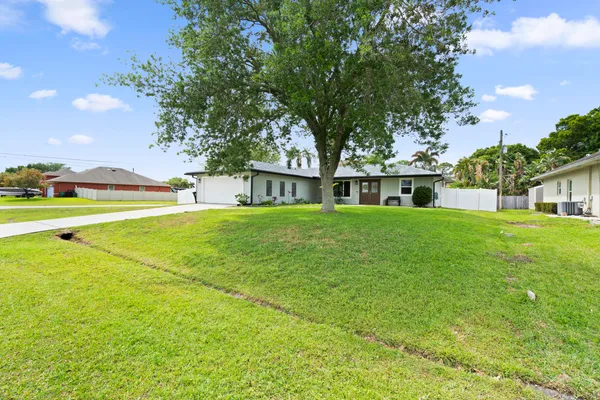 a front view of a house with a garden and plants
