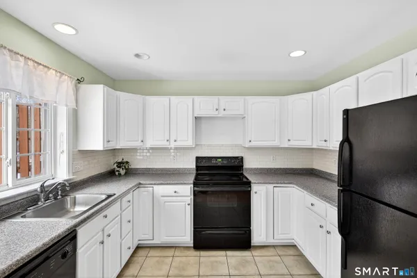 a kitchen with a refrigerator and a stove top oven