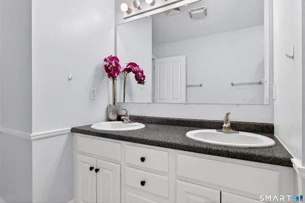 a bathroom with a granite countertop sink and a mirror