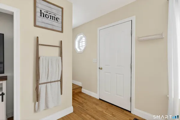 a living room with a flat screen tv and a wooden floor