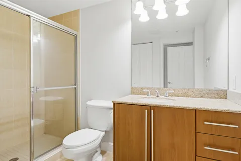 a bathroom with a granite countertop sink toilet and shower