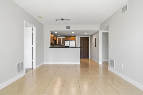 wooden floor in an empty room with a kitchen