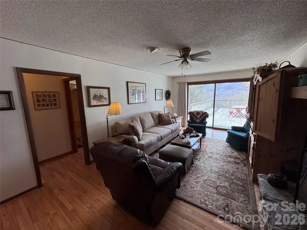 a living room with furniture a flat screen tv and a refrigerator