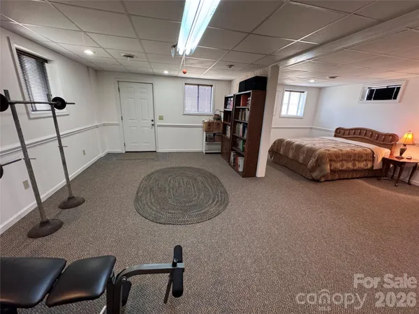 a spacious bedroom with a bed a desk and large mirror