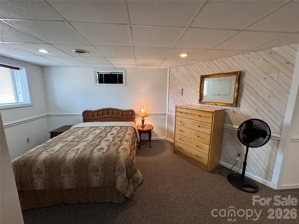 a bedroom with a bed and a flat tv screen on the dresser