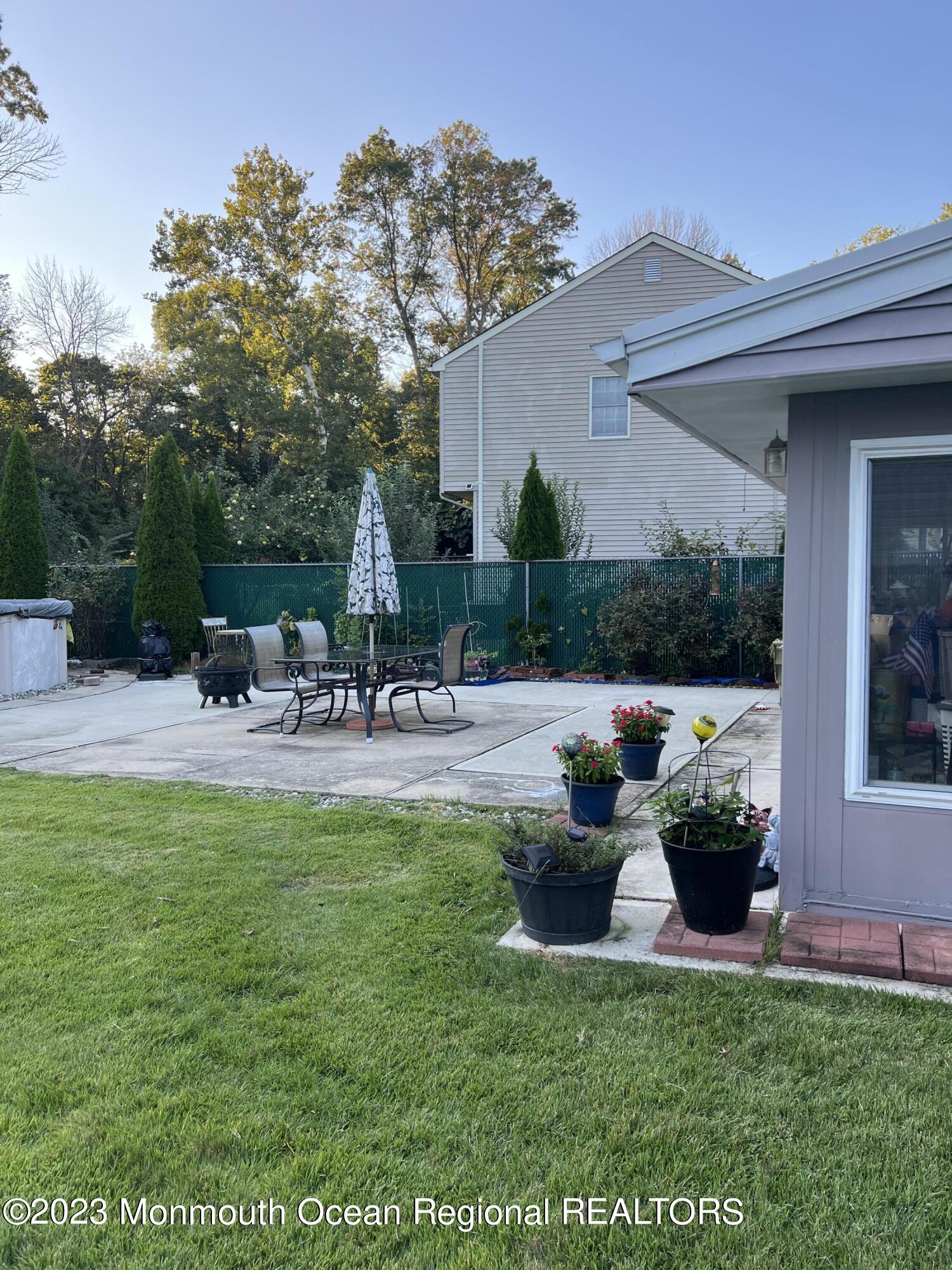 42 Epping Drive Kenilworth, NJ 07033 - Photo 18 of 22 a view of a patio with couches and a table and chairs with plants and trees