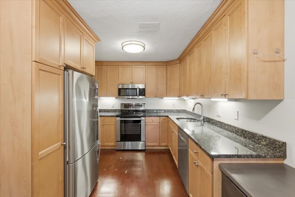 360 Neponset Street, Unit 702 Canton, MA 02021 - Photo 6 of 21 a kitchen with stainless steel appliances granite countertop a refrigerator sink and stove