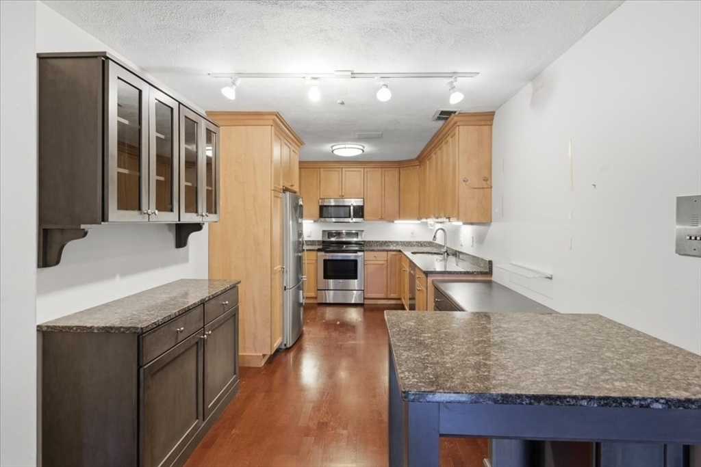 360 Neponset Street, Unit 702 Canton, MA 02021 - Photo 8 of 21 a kitchen with stainless steel appliances granite countertop a sink stove and refrigerator