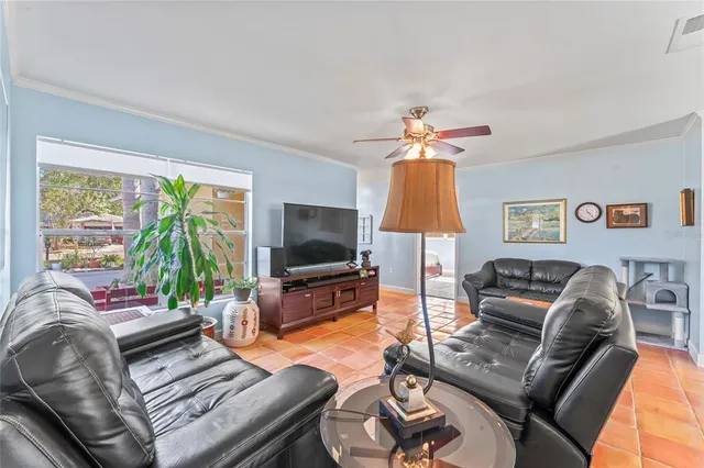 a living room with furniture a flat screen tv and a large window