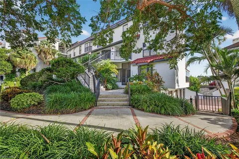 a front view of a house with a yard and fountain