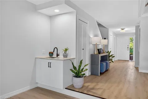 a hallway with view of living room and wooden floor