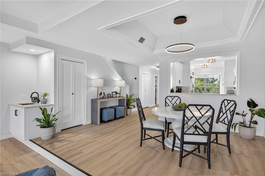 111 La Peninsula Boulevard, Unit 111 Naples, FL 34113 - Photo 12 of 33 a view of a dining room with furniture and wooden floor