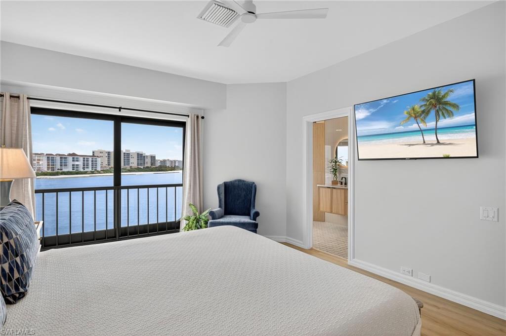 111 La Peninsula Boulevard, Unit 111 Naples, FL 34113 - Photo 15 of 33 a bedroom with a bed and a painting on the wall