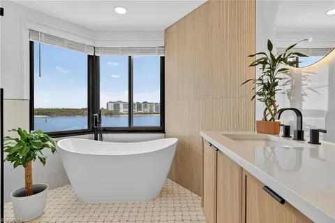 a white bath tub sitting in a bathroom next to a window