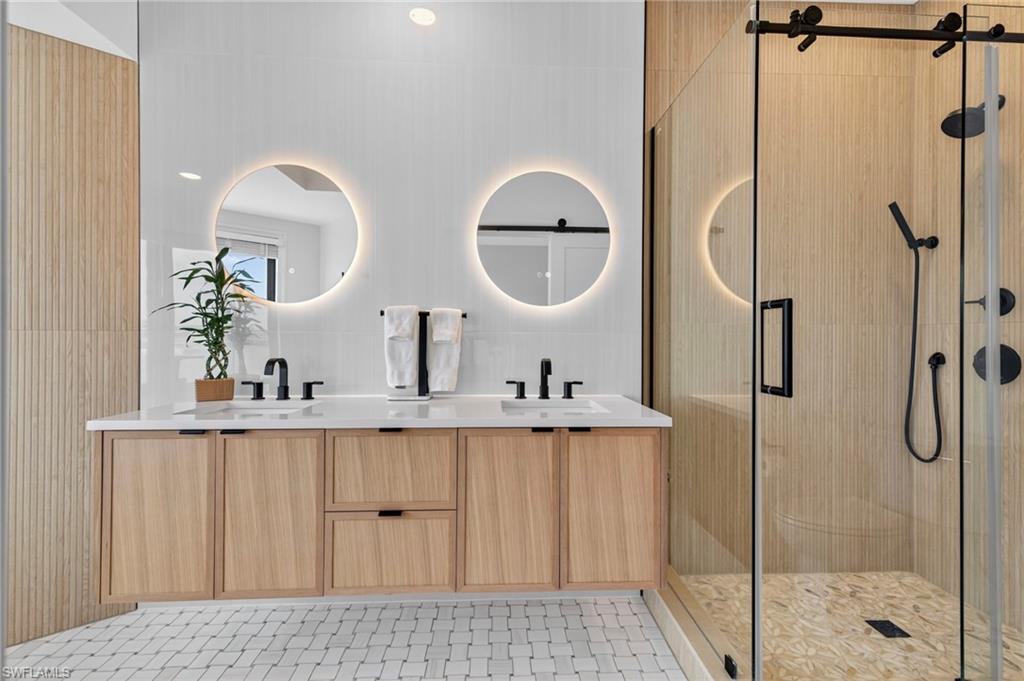 111 La Peninsula Boulevard, Unit 111 Naples, FL 34113 - Photo 19 of 33 a bathroom with a sink and mirror