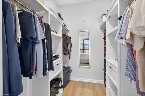 a view of walk in closet with clothes and shoes