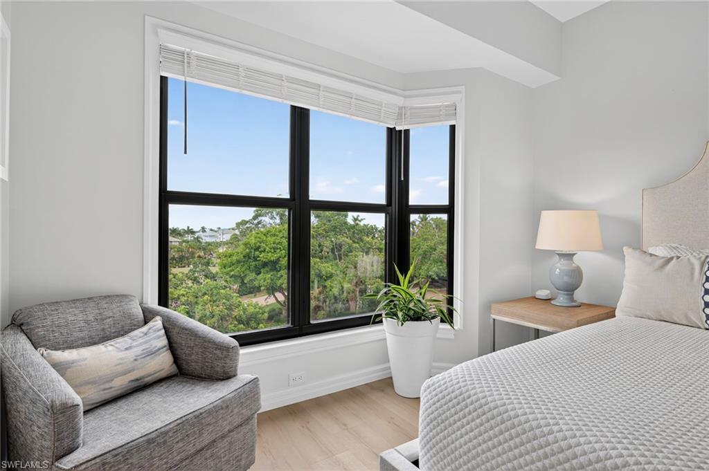 111 La Peninsula Boulevard, Unit 111 Naples, FL 34113 - Photo 22 of 33 a bedroom with a bed and glass window