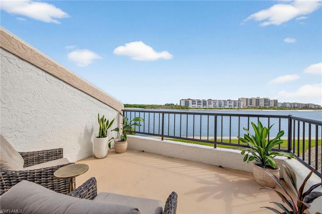 111 La Peninsula Boulevard, Unit 111 Naples, FL 34113 - Photo 29 of 33 a balcony with potted plants and ocean view