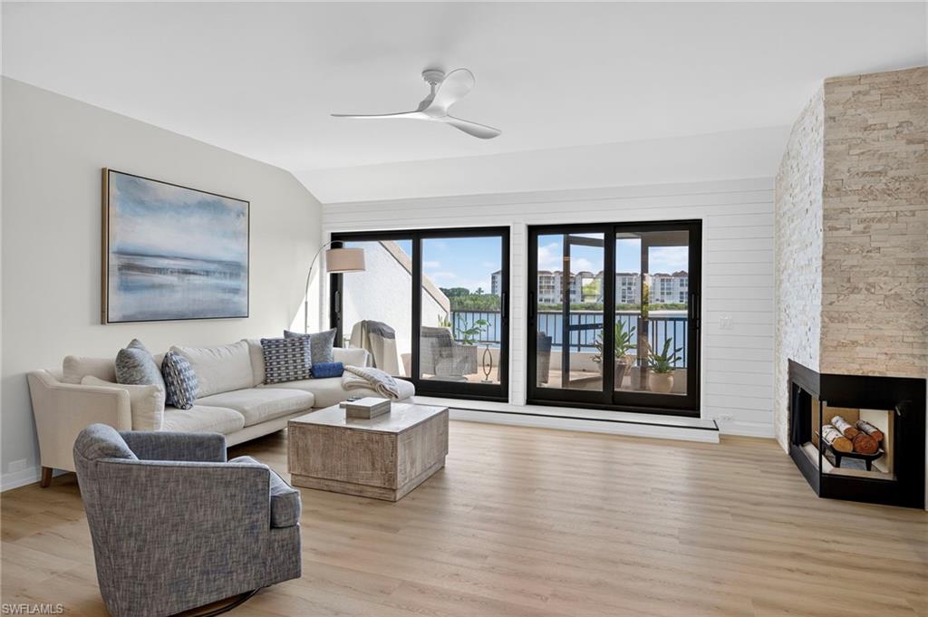 111 La Peninsula Boulevard, Unit 111 Naples, FL 34113 - Photo 3 of 33 a living room with furniture and a fireplace