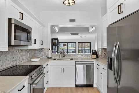 a kitchen with stainless steel appliances granite countertop a sink stove refrigerator and cabinets
