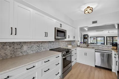 a kitchen with granite countertop a sink and a stove top oven