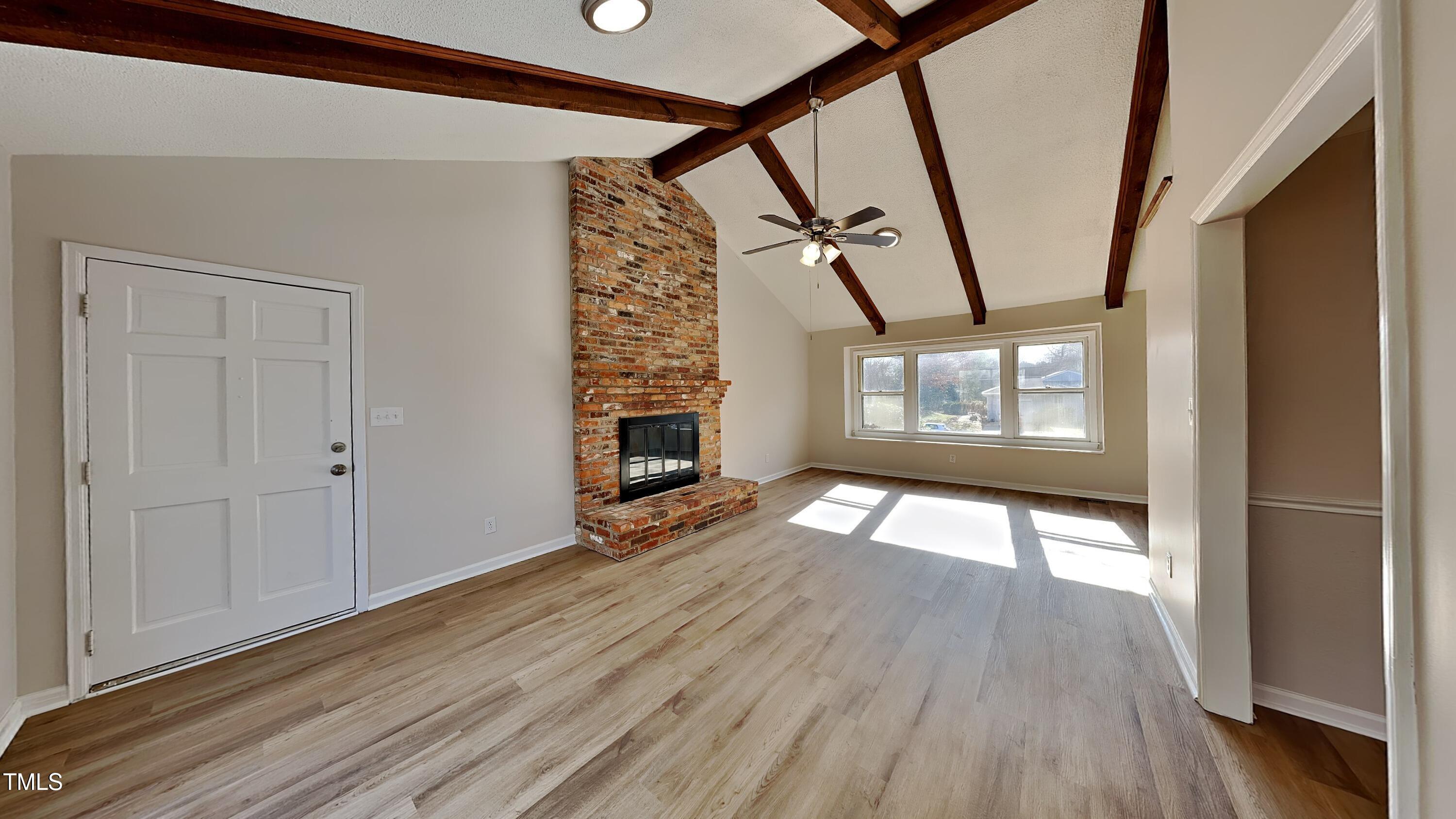 1921 Port Royal Road Raleigh, NC 27609 - Photo 3 of 18 a view of an empty room with wooden floor fireplace and a window