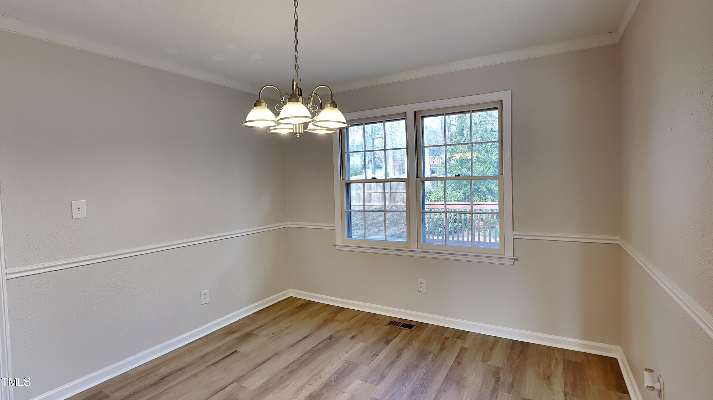 1921 Port Royal Road Raleigh, NC 27609 - Photo 8 of 18 a view of an empty room with wooden floor and a window