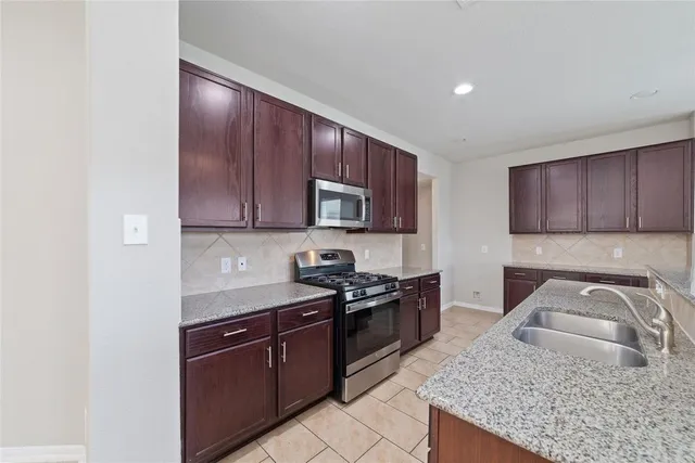 a kitchen with granite countertop wooden cabinets and a stove top oven
