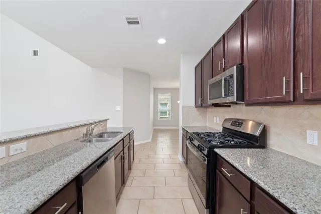a kitchen with granite countertop stainless steel appliances and wooden cabinets
