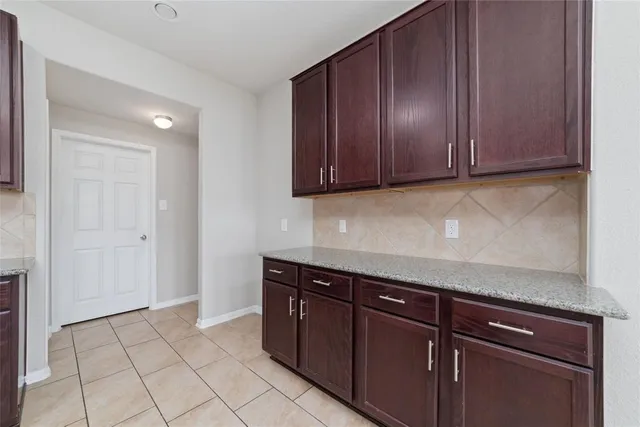 a view of kitchen with granite countertop cabinets