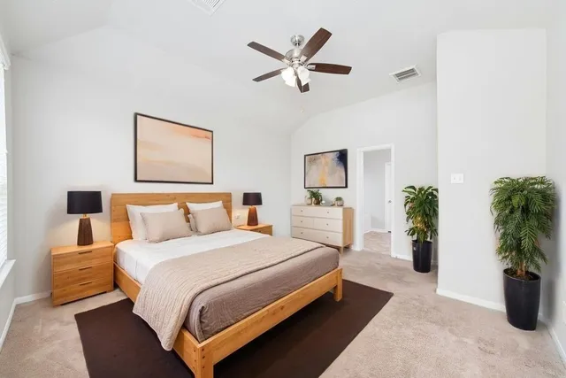 a bedroom with a large bed and a potted plant