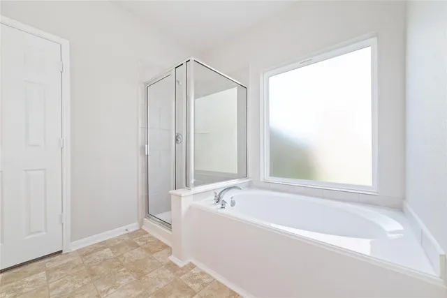 a white bath tub sitting next to a shower