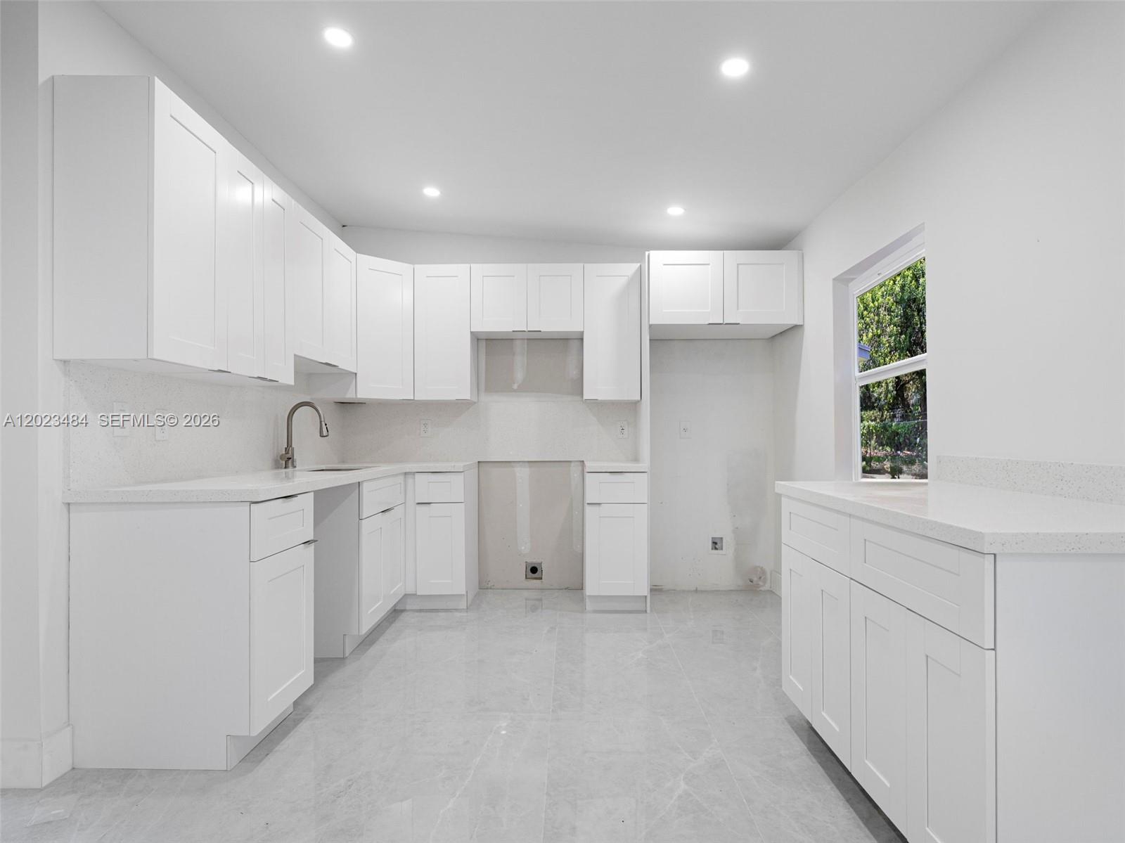 1961 Rutland Street Opa-Locka, FL 33054 - Photo 9 of 33 a kitchen with white cabinets and white appliances