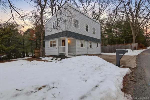 a front view of a house with a yard covered in snow