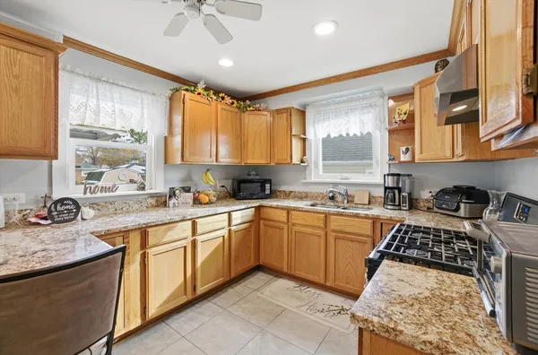 a kitchen with stainless steel appliances granite countertop a stove a sink and a microwave