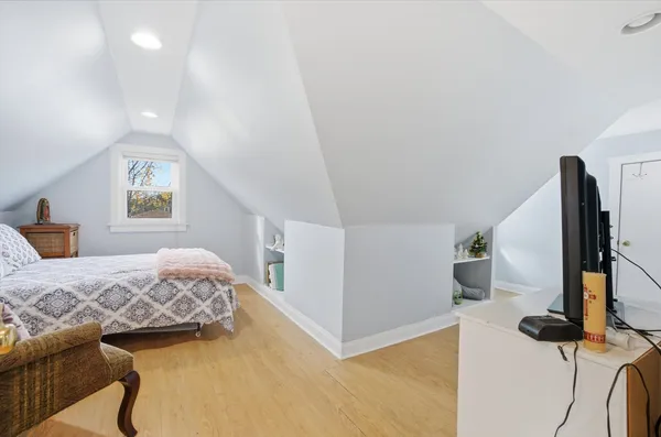 a bedroom with a bed and a flat tv screen on the dresser