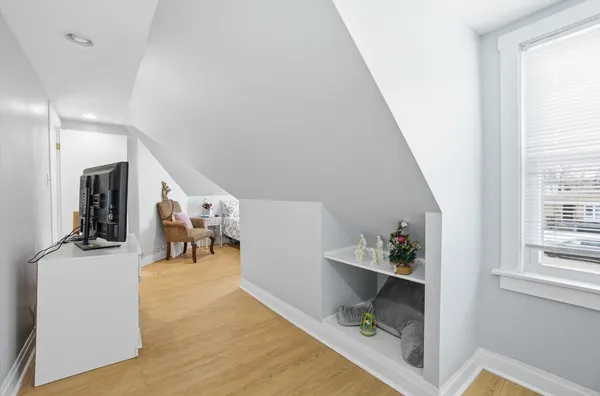 a view of a hallway with furniture and a window