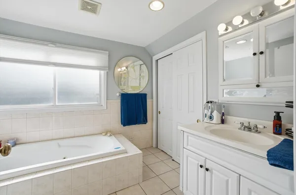 a bathroom with a bathtub sink and mirror
