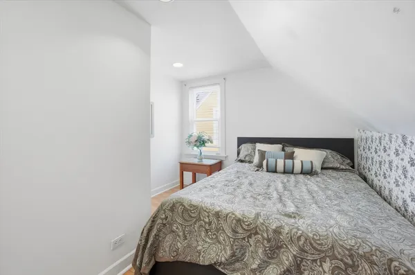 a bedroom with a large bed and a potted plant