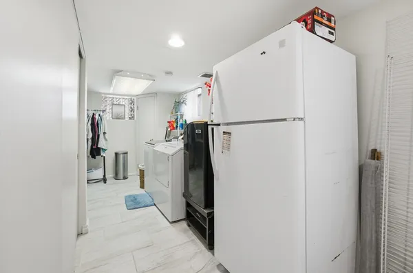 a view of a storage & utility room with a refrigerator