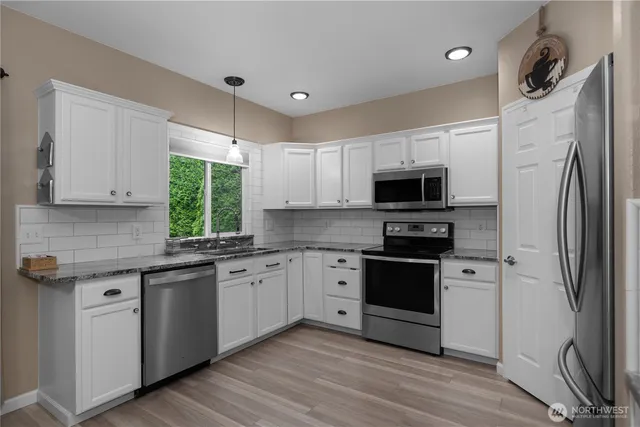 a kitchen with stainless steel appliances a stove a sink and a refrigerator