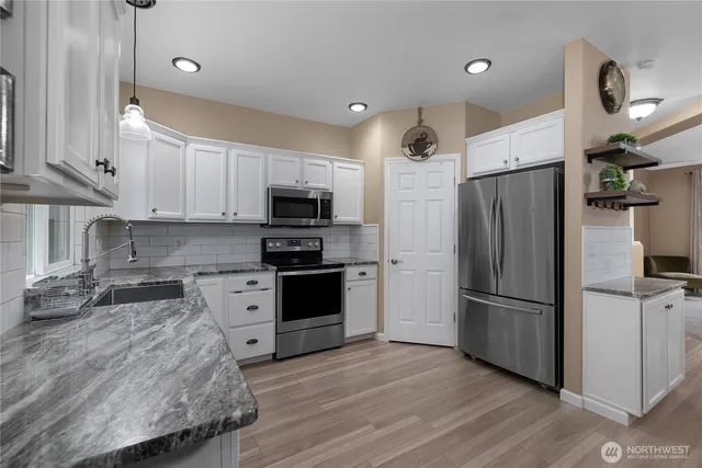 a kitchen with stainless steel appliances a refrigerator sink and microwave