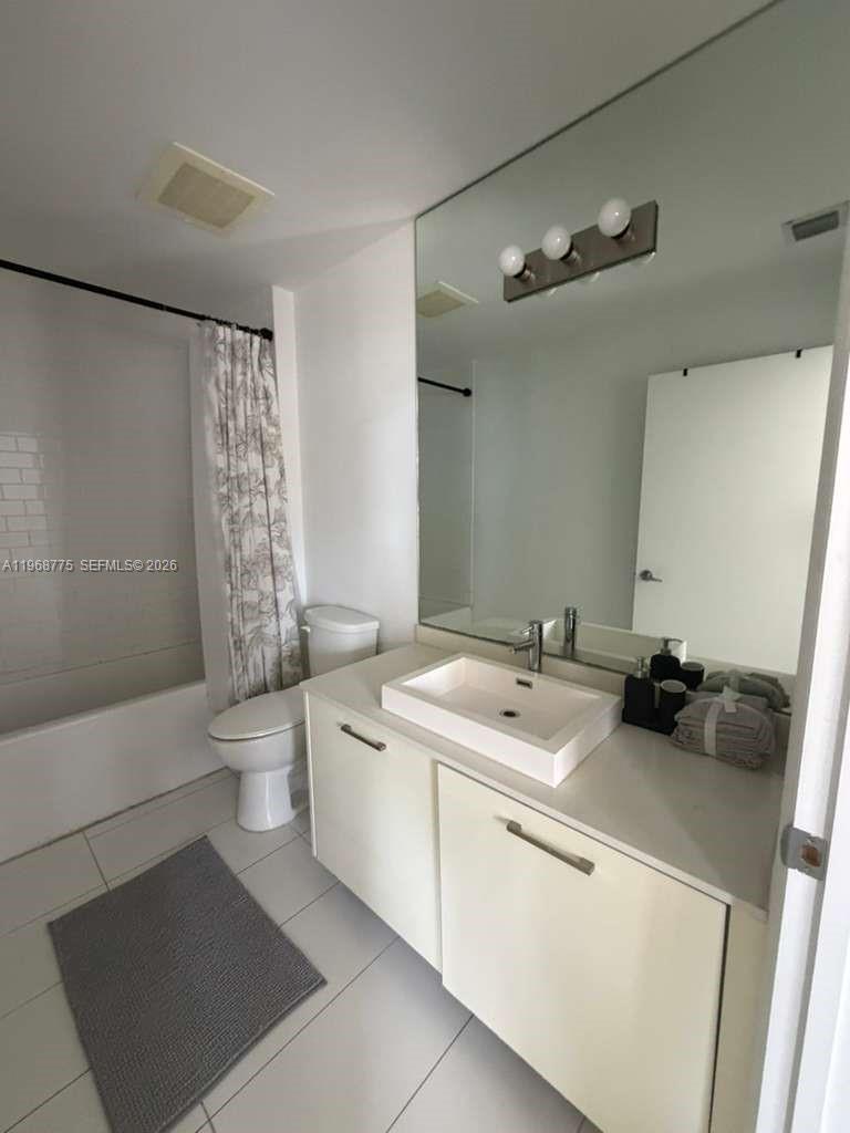 151 Southeast 1st Street, Unit 909 Miami, FL 33131 - Photo 2 of 29 a bathroom with a sink a toilet and shower